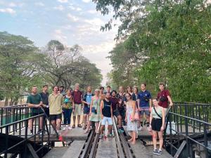 a group of people standing on a bridge at Asleep Hostel in Kanchanaburi City