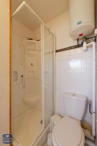 La salle de bains blanche est pourvue d'une douche et de toilettes. dans l'établissement Saint Léger les Mélèzes, à Saint-Léger-les-Mélèzes