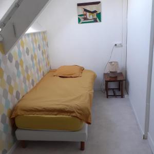 ein kleines Schlafzimmer mit einem Bett und einer Treppe in der Unterkunft Chambres d'hôtes GOBILLON in Maintenon