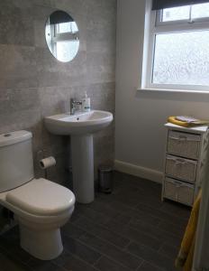 a bathroom with a toilet and a sink and a mirror at York City Homestays in York