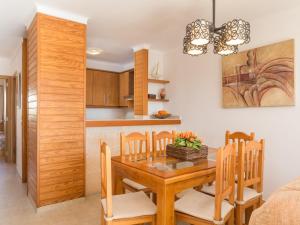 uma cozinha e sala de jantar com uma mesa de madeira e cadeiras em Apartament Francesca Beach with Pool na Alcúdia