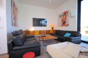 salon z dwoma krzesłami i kanapą w obiekcie Deluxe VILLA LAVANDA Las Colinas DEHESA DE CAMPOAMOR with HEATED POOL w mieście Campoamor