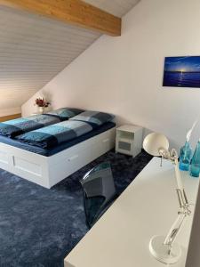 1 dormitorio con 1 cama y escritorio con lámpara en Ferienhaus BMB mit Blick auf den Bodensee und Konstanz en Bottighofen