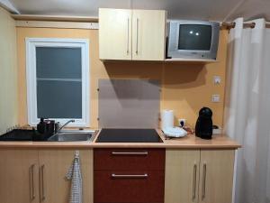 una pequeña cocina con fregadero y microondas en Slow M'Ocean Villa en Pataias