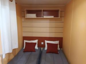 a small room with a bed with two pillows at Slow M'Ocean Villa in Pataias +20 photos