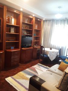 sala de estar con sofá y TV en Aconchego da te en Río de Janeiro