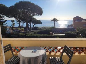 uma mesa e cadeiras numa varanda com vista para o oceano em Villa Esmeralda em Les Issambres