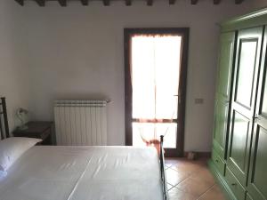 - une chambre avec un lit blanc et une fenêtre dans l'établissement La Ramaccia: relax a Montescudaio, à Montescudaio