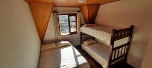 a room with two bunk beds and a window at Apartamento em Campos do Jordão próximo ao Capivari in Campos do Jordão