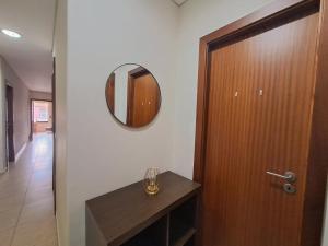 a bathroom with a wooden door and a mirror at Private Room at Fatima's in Porto +1 photo