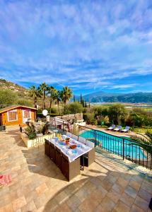 um pátio com uma mesa ao lado de uma piscina em Villa Canarias em Saint-Jeannet