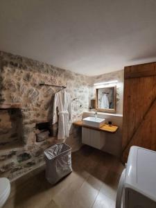 baño con lavabo y pared de piedra en Filia's House (The House of Friendship), en Areopoli