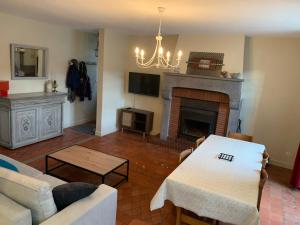 salon z kanapą i kominkiem w obiekcie Charmant appartement jardin/parking privé 4 personnes w mieście Bourboule