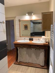 łazienka z dwiema umywalkami i dużym lustrem w obiekcie Charmant appartement jardin/parking privé 4 personnes w mieście Bourboule
