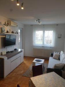 a living room with a couch and a tv at Apartman Džakula in Zagreb