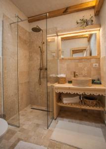 La salle de bains est pourvue d'une douche et d'un lavabo. dans l'établissement Thomhof Chalets, à Bran
