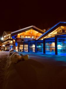 a building at night with snow in front of it at Hotel Alpina in Morzine