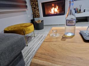 a bottle of wine sitting on a table in front of a fireplace at Damona 2BR Luxury Home with garden - κοντά στο κέντρο in Heraklio Town