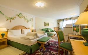 a bedroom with a large bed and a living room at Hotel Sassongher in Corvara in Badia