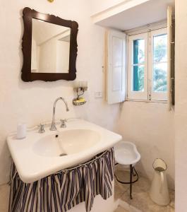 baño con lavabo y espejo en la pared en Masseria Tagliente, en Martina Franca