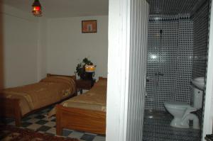 a bedroom with a bed and a bathroom with a toilet at Riad Freija-TAROUDANT in Sidi Abd el Kader