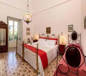 - une chambre dotée d'un grand lit avec des draps rouges et blancs dans l'établissement Masseria Tagliente, à Martina Franca