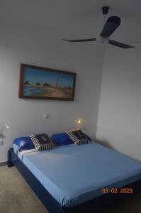 LA VELA في Palmeira: غرفة نوم بسرير ازرق مع مروحة سقف