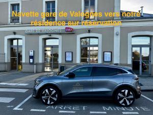 un'auto parcheggiata in un parcheggio di fronte a un edificio di OXXOTEL a Valognes