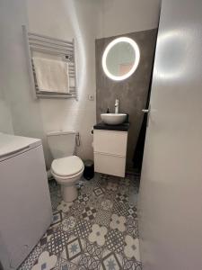 ein Badezimmer mit einem WC, einem Waschbecken und einem Spiegel in der Unterkunft Studio Nice port in Nizza