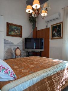 Cianciana的住宿－D'ALTRITEMPI-Elegance in Cianciana.，一间卧室配有一张大床和一台平面电视