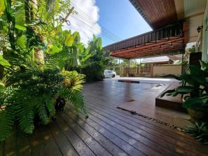 a house with a wooden deck with plants at De rae nong in Ranong