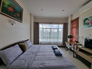 - une chambre avec un grand lit et un bureau dans l'établissement De rae nong, à Ranong