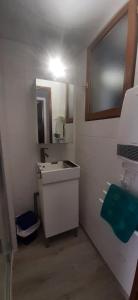 Appartement 4 personnes Porté Puymorens في بورتيه بيومورينز: حمام مع حوض ومرآة