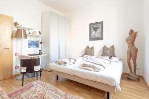 ein Schlafzimmer mit einem Bett, einem Schreibtisch und einem Stuhl in der Unterkunft Victoria Apartment in Bozen