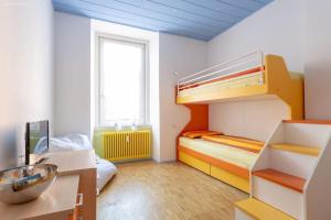 ein Zimmer mit zwei Etagenbetten und einem Schreibtisch in der Unterkunft Victoria Apartment in Bozen + 2 Fotos