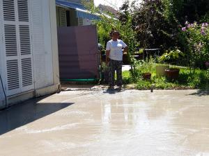 a woman standing outside a house with water on the ground at Studio avec wifi a Argenteuil in Argenteuil