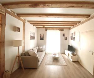 a living room with a couch and a tv at Hostellerie des Princes-Evêques - Le Secret in Porrentruy