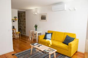 sala de estar con sofá amarillo y mesa en Olival 54 Apartments, en Oporto