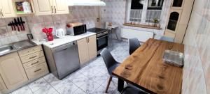 - une cuisine avec une table et une table en bois dans l'établissement Agroturystyka Pod Lipa, à Boreczno