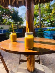 two jars of orange juice sitting on a wooden table at Masaki Anne H & Apartment in Dar es Salaam