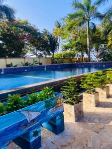 un banco azul frente a una piscina en Masaki Anne H & Apartment, en Dar es Salaam