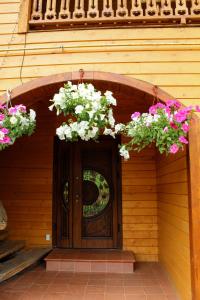 a wooden door with two flower baskets on it at Manor "U Bervinovy" in Yaremche
