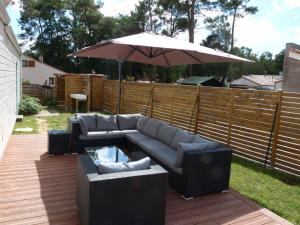 ジャール・シュル・メールにあるVilla Les Fougèresのパティオ(ソファ、テーブル、パラソル付)