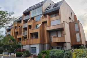 un immeuble d'appartements avec une façade en bois dans l'établissement Superbe appartement cosy - Plage des minimes, à La Rochelle