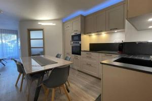 cocina con mesa y sillas en Superbe appartement cosy - Plage des minimes en La Rochelle