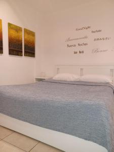 Bett in einem Zimmer mit Gemälden an der Wand in der Unterkunft Casamassimi apartment in Bari