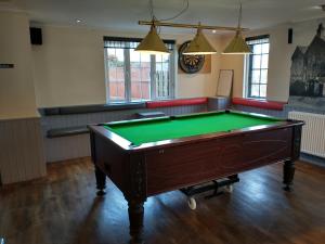 a room with a pool table in the middle at Llanina Arms in Llanarth