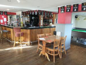 een restaurant met een tafel en een bar met een pooltafel bij Llanina Arms in Llanarth