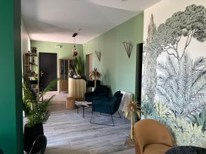 a living room with chairs and plants on the wall at Hôtel Paradis in Bormes-les-Mimosas