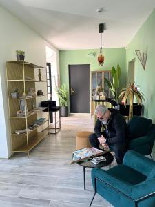 a man sitting on a couch in a living room at Hôtel Paradis in Bormes-les-Mimosas